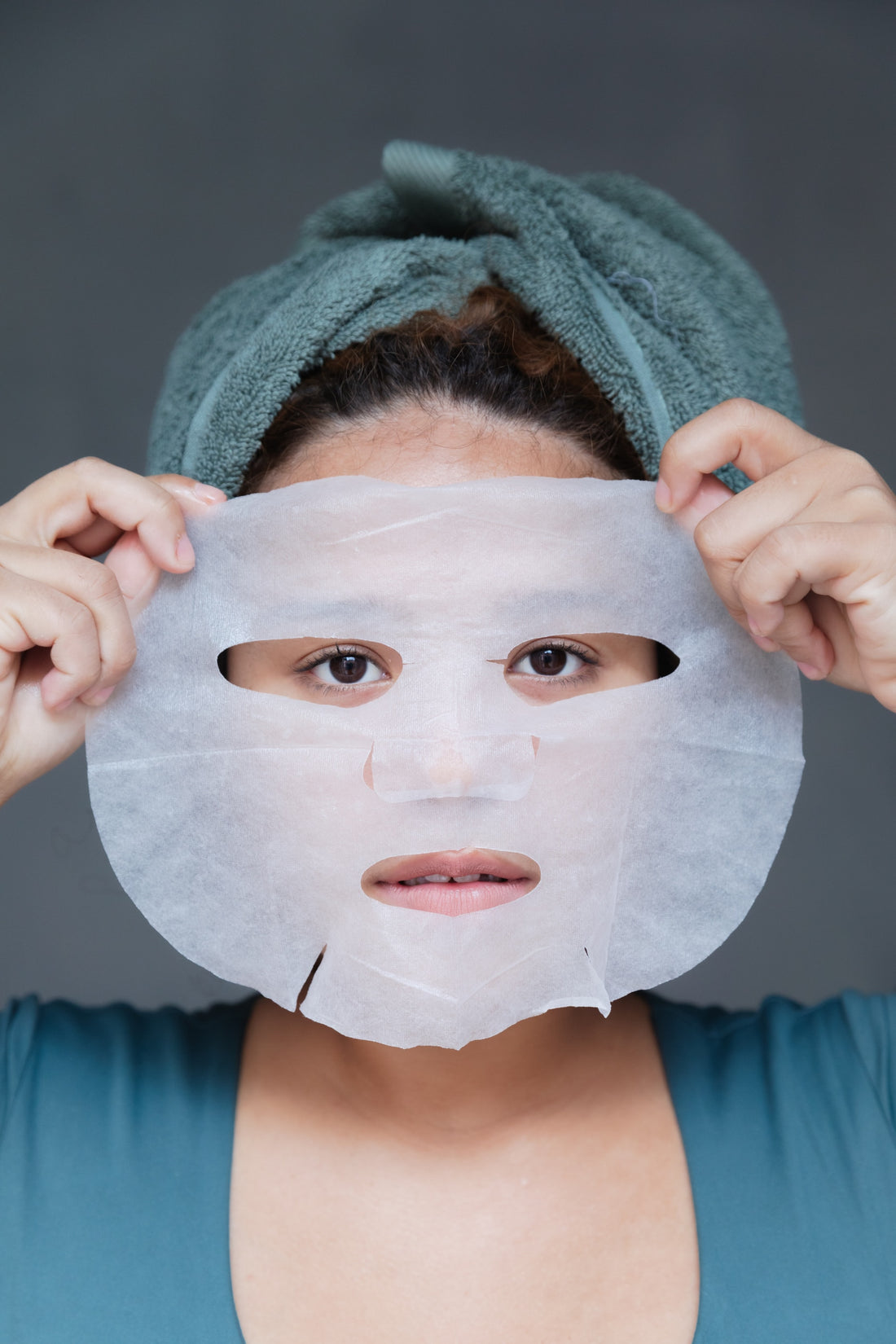 Close-up of a woman applying cream to her face during her daily skincare routine, showcasing the benefits of a K-Beauty regimen.